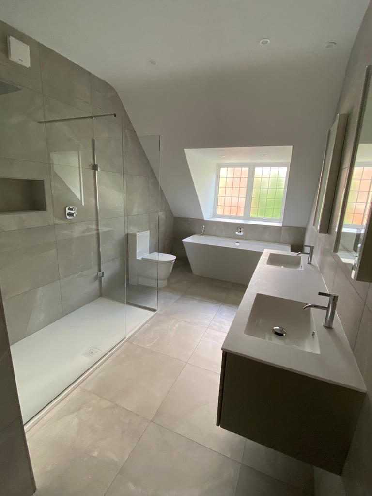 Modern bathroom with walk-in shower, freestanding tub, double sink vanity, and windows with natural light